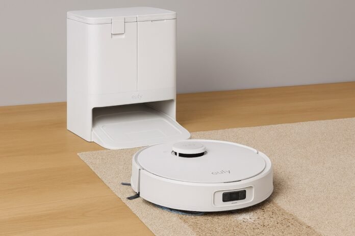 eufy-x10-pro-omni-robot-vacuum-with-dock-in-use eufy X10 Pro Omni robot vacuum cleaning a carpeted floor with its docking station beside it.